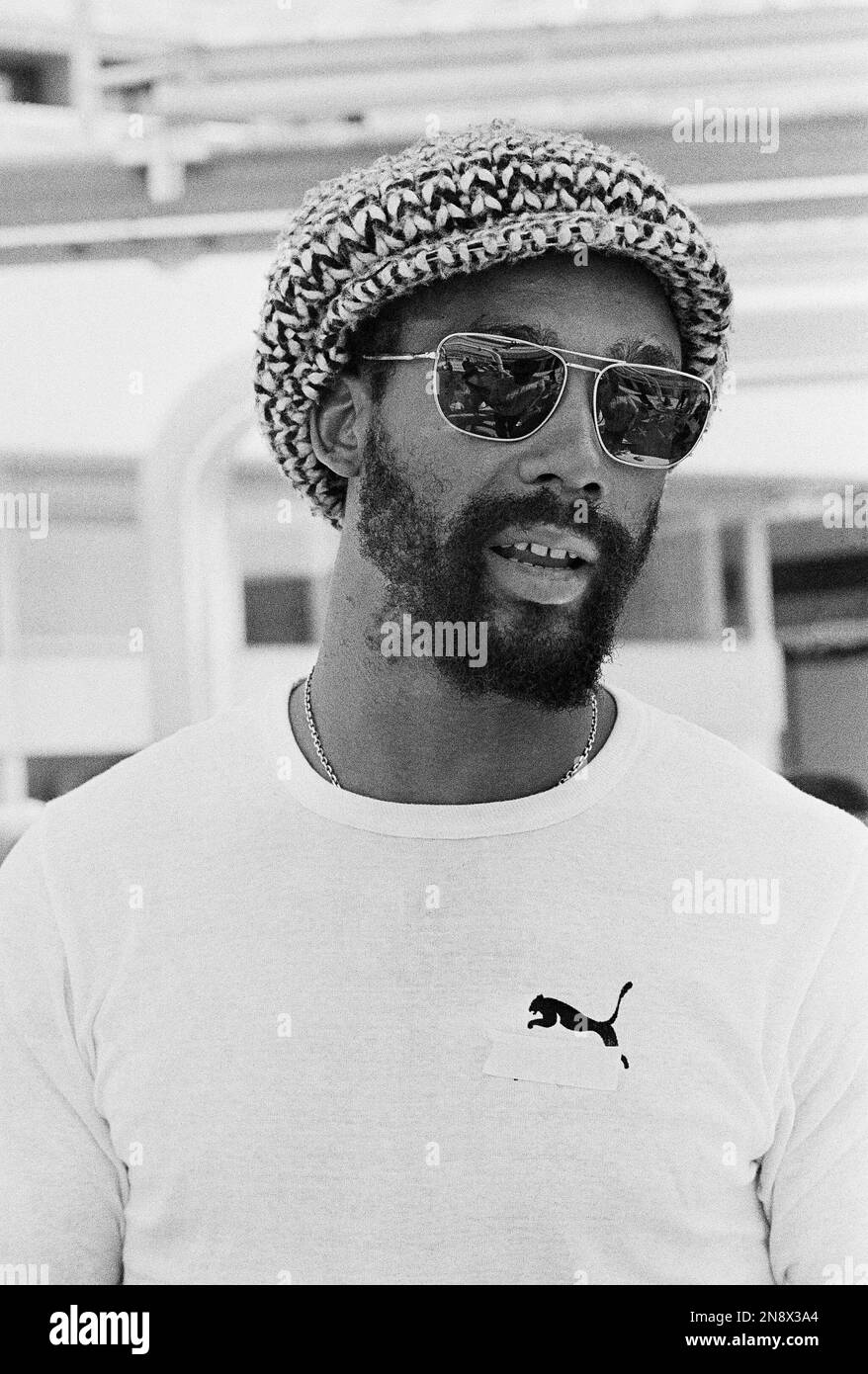 John Carlos, American gold medal sprinter from 1968 Mexico Olympics, wears a t-shirt advertising the "Puma" brand of track shoes, but the "Puma" name taped over, in Olympic village after officials