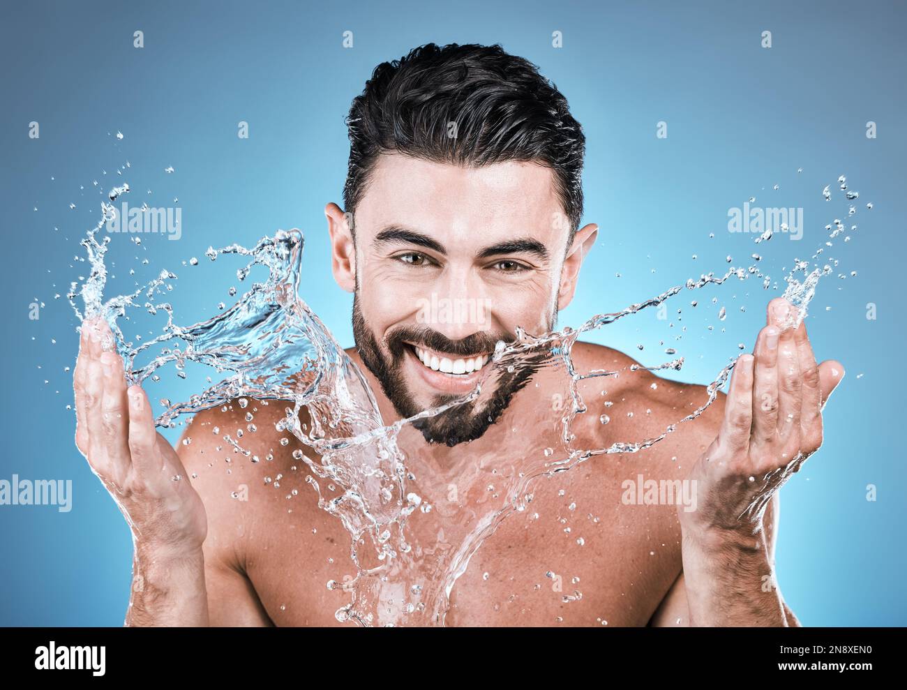 Portrait, water splash and a man model washing his face in studio on a ...