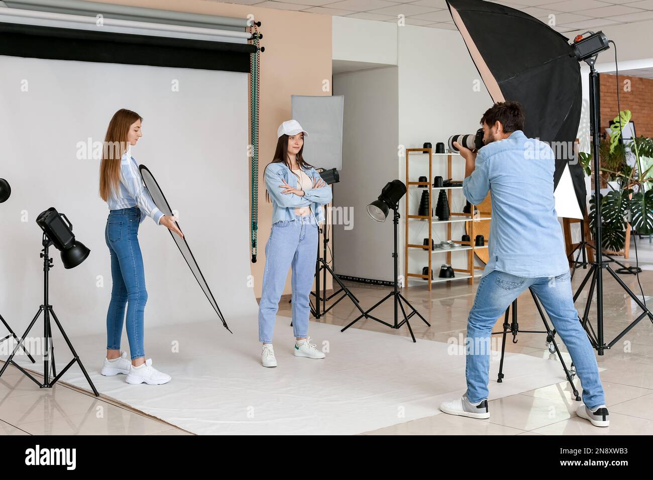 Male photographer and his assistant working with beautiful model in ...