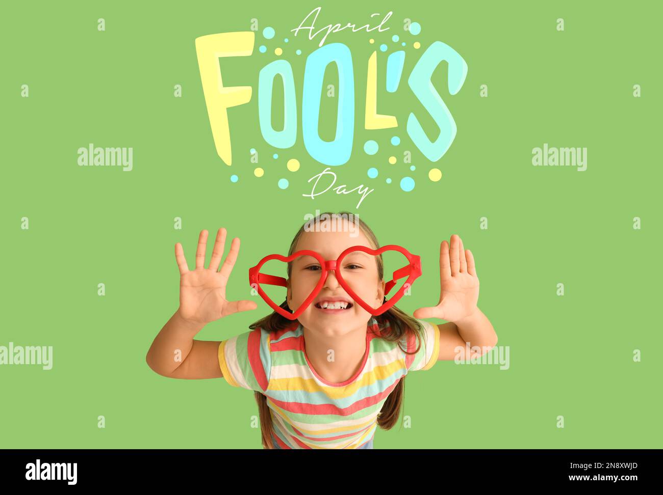 Little girl wearing funny eyeglasses on green background. April Fools ...