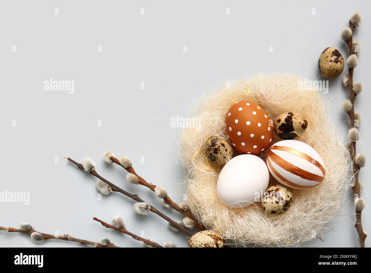 Nest with Easter eggs and willow branches on light background Stock ...