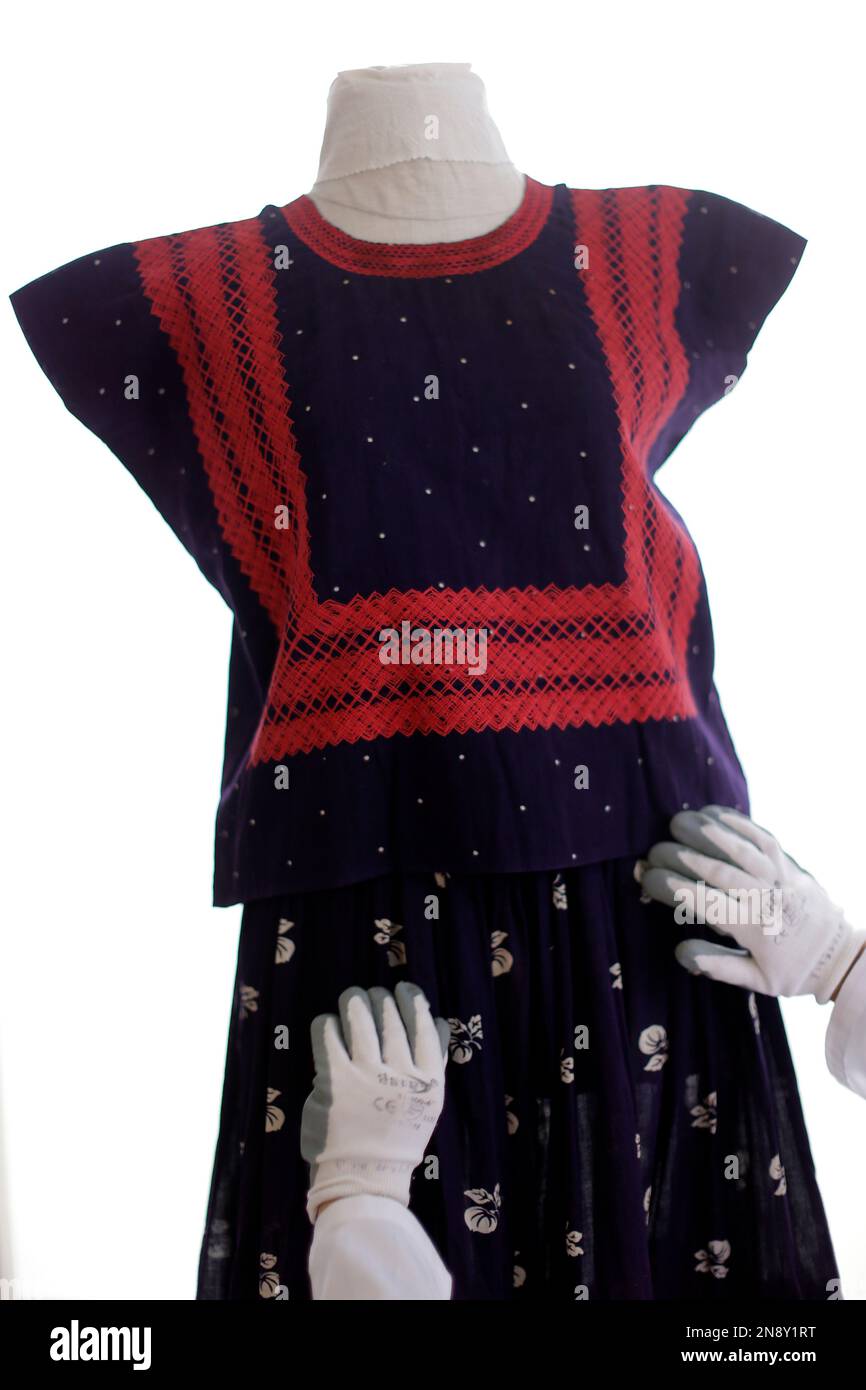 Museum keeper Ximena Gomez dresses a mannequin with an indigenous shirt