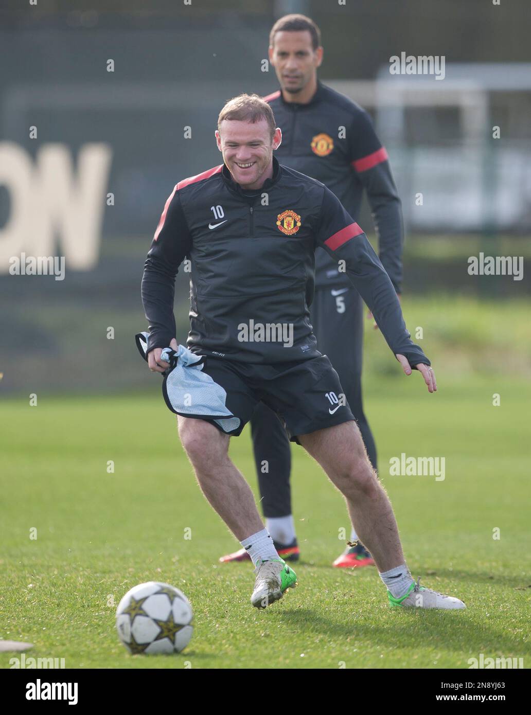 Manchester United's Wayne Rooney, centre, trains as teammate Rio