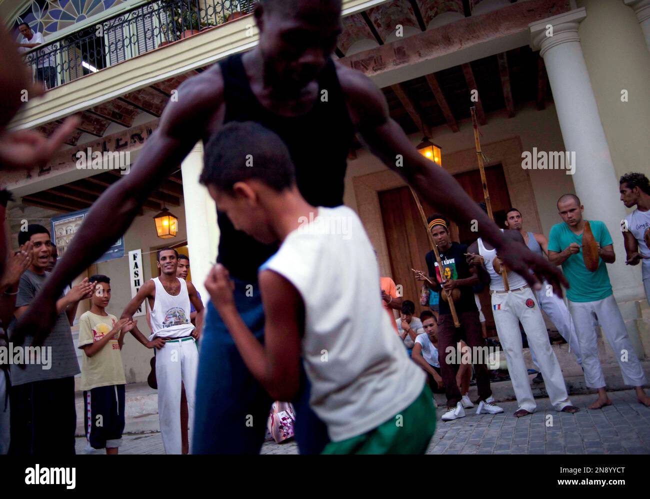 A capoeira instructor jokes with a child member of his group during a