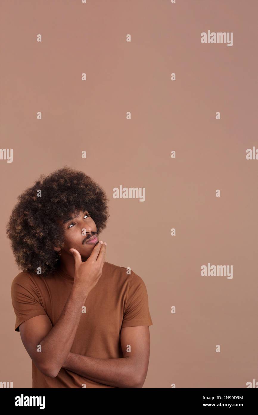African man with hand on face and thoughtful expression Stock Photo
