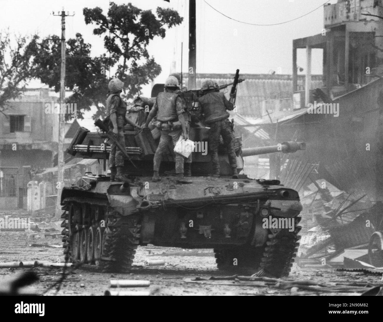 South Vietnamese troops use a tank to blast Viet Cong snipers from ...