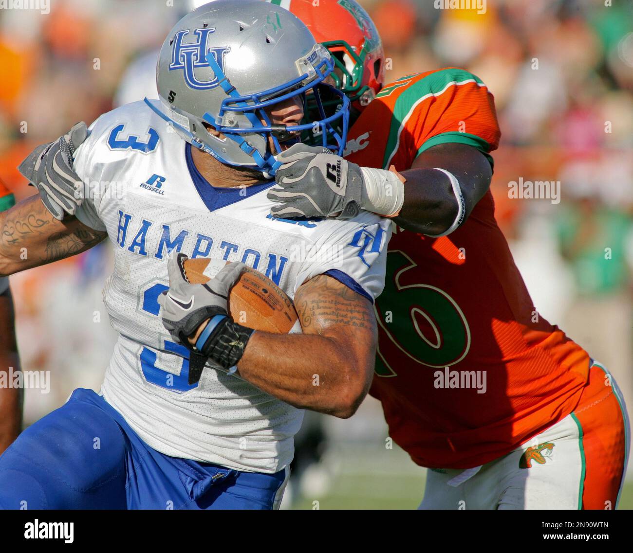 Hampton running back Jeremiah Schwartz (3) has his facemask grabbed by  Florida A&M linebacker Bobby Jackson, top left, during the first half of an  NCAA college football game on Saturday, Sept. 15