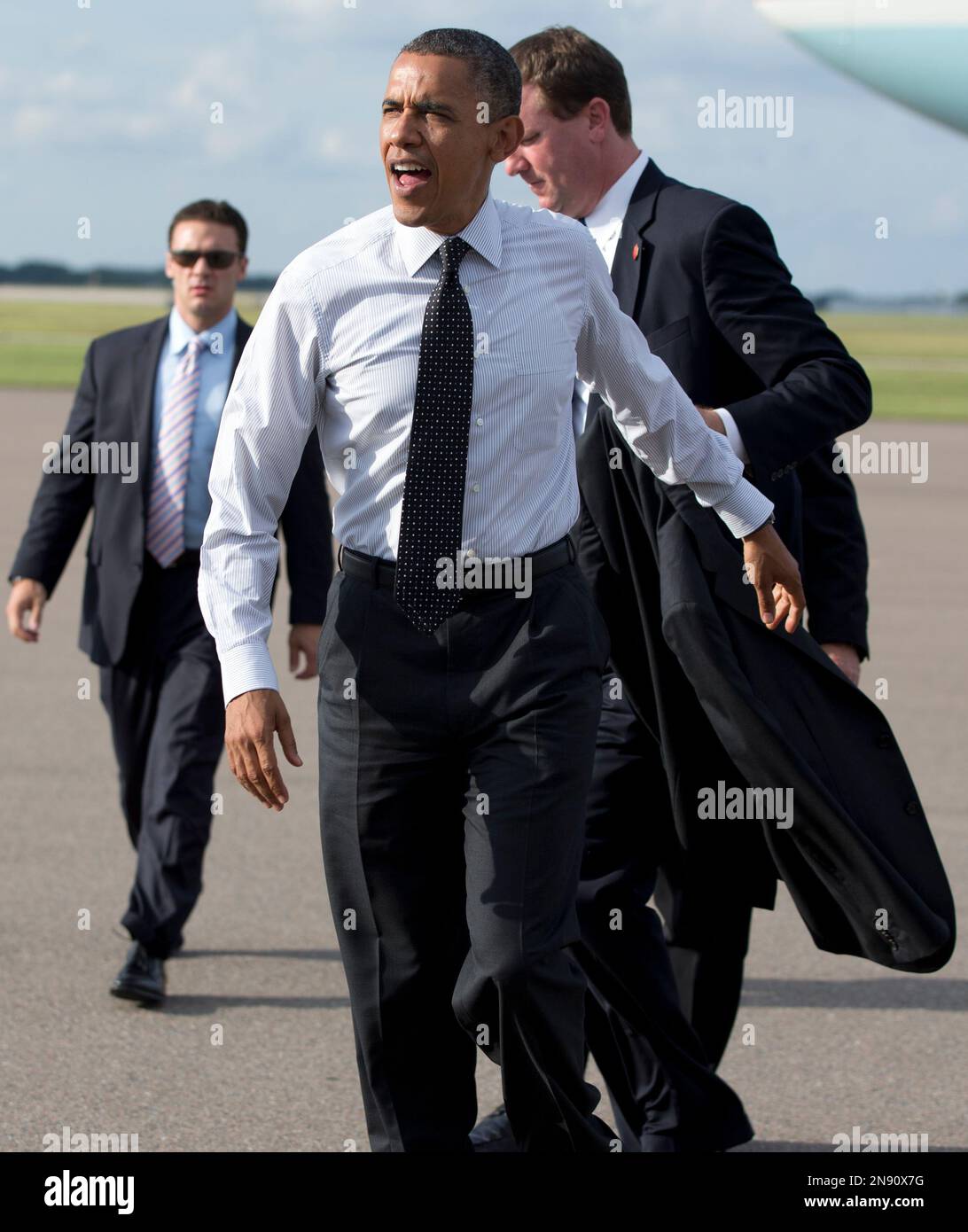 President Barack Obama takes off his jacket as he arrives at Tampa