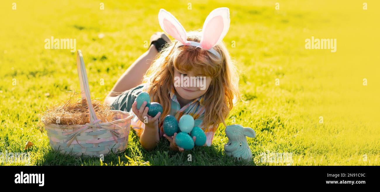 Child Boy Hunting Easter Eggs Laying On Grass Kid In Rabbit Bunny Child boy hunting easter eggs laying on grass kid in rabbit bunny