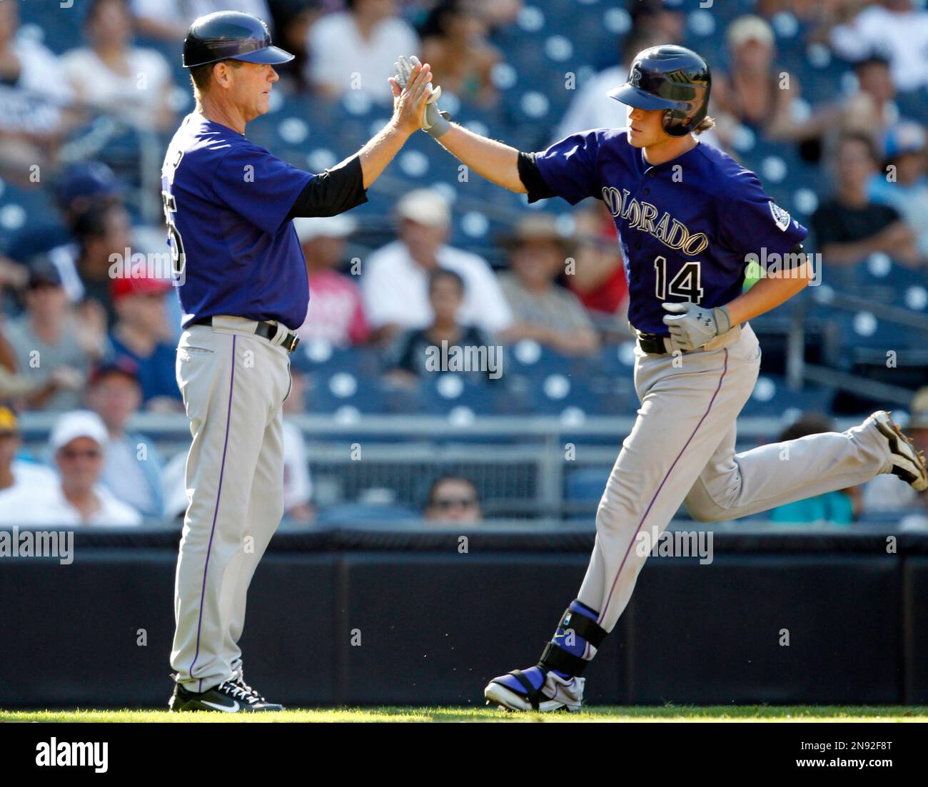 Colorado Rockies third base coach Rich Dauer, left, congratulates Josh