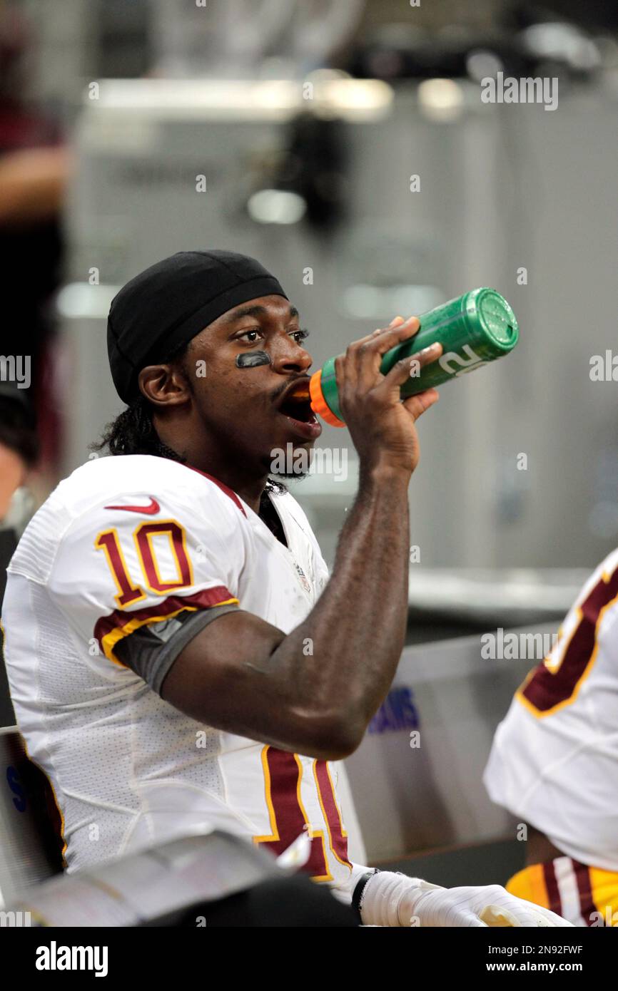 Washington Redskins quarterback Robert Griffin III drinks on the bench ...