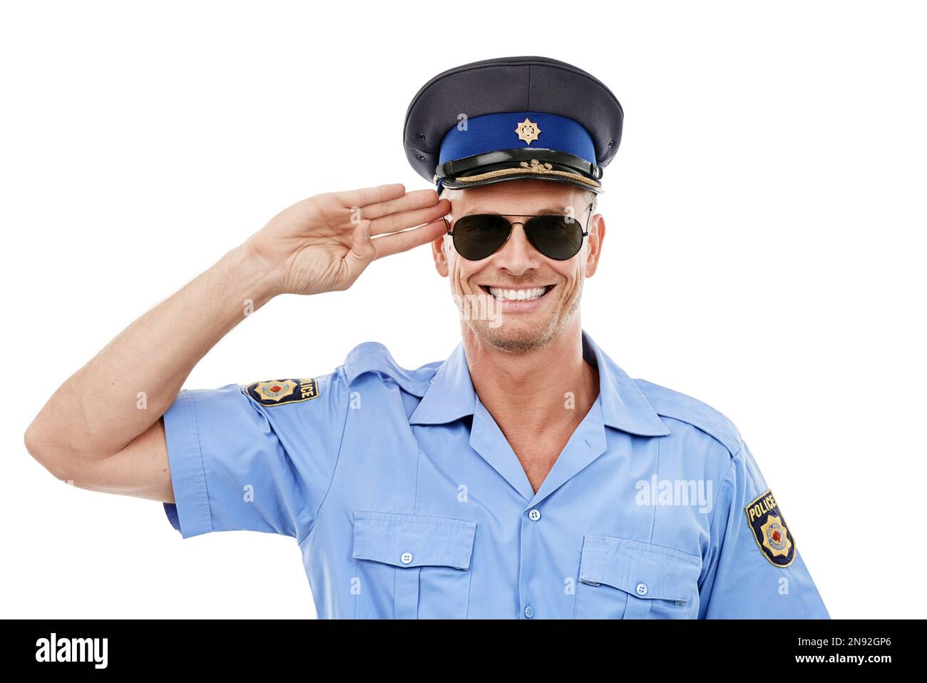 Security, salute and face of police smile on white background for authority, public safety and service. Community justice, law enforcement and Stock Photo