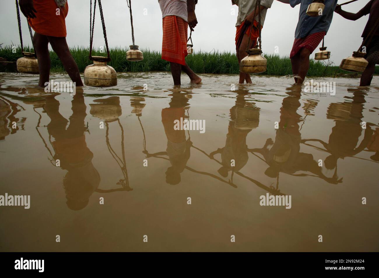 Indian Hindu devotees carrying metal pots filled with water from the
