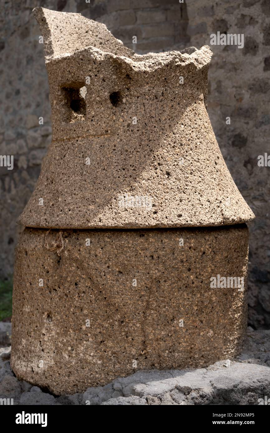 Ancient roman stone grain mill in the ruins of Pompeii Stock Photo
