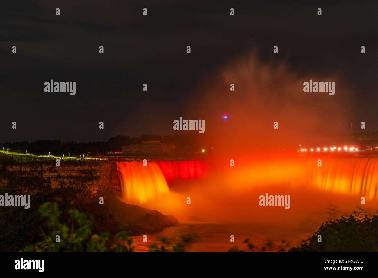 Niagara Falls lit up in red and gold. Ontario, Canada. Stock Photo