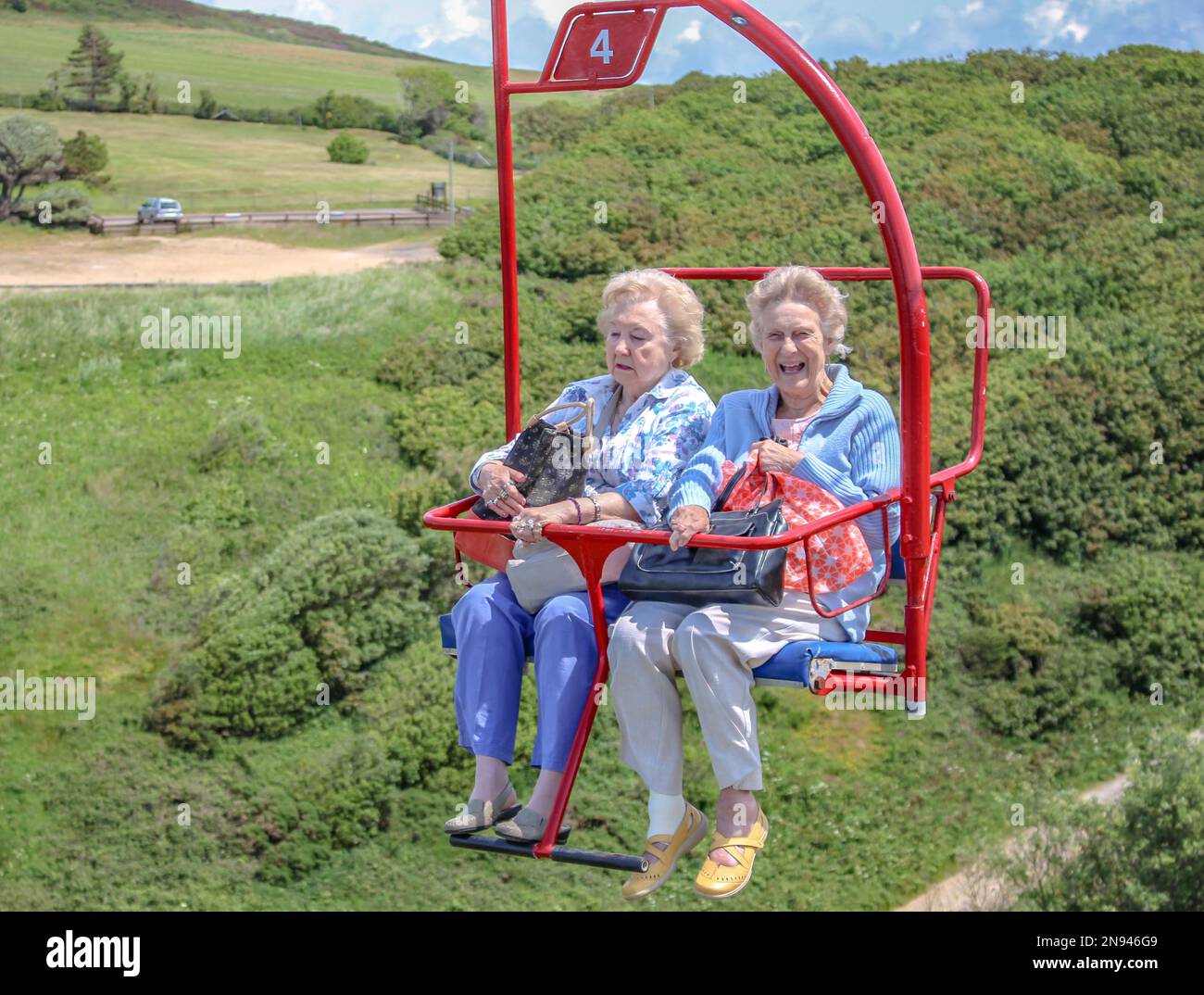 https://c8.alamy.com/comp/2N946G9/happy-old-ladies-on-the-chairlift-in-needles-parkisle-of-wight-2N946G9.jpg