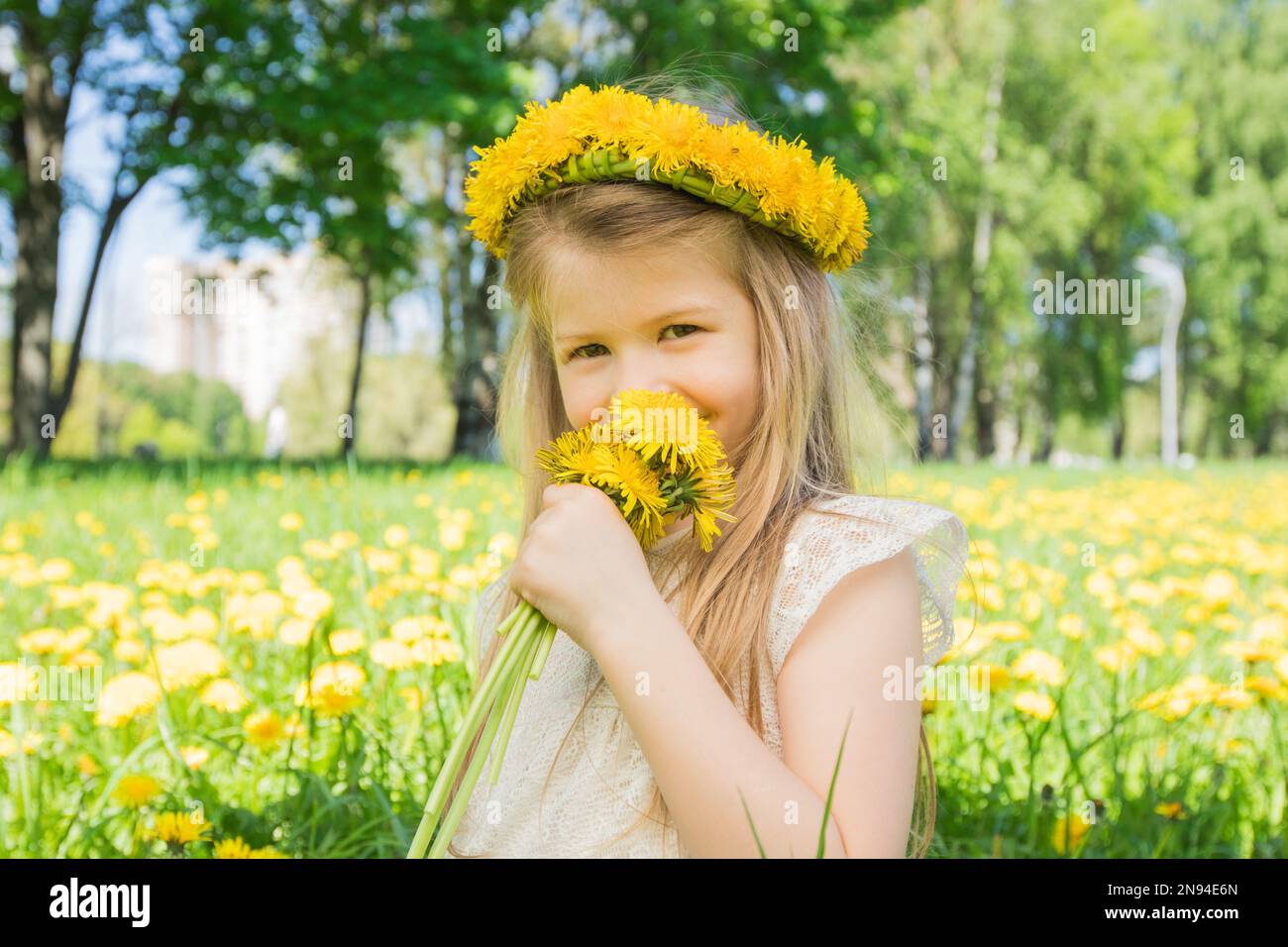 Little girl enjoys the smell of flowers in the meadow Stock Photo - Alamy