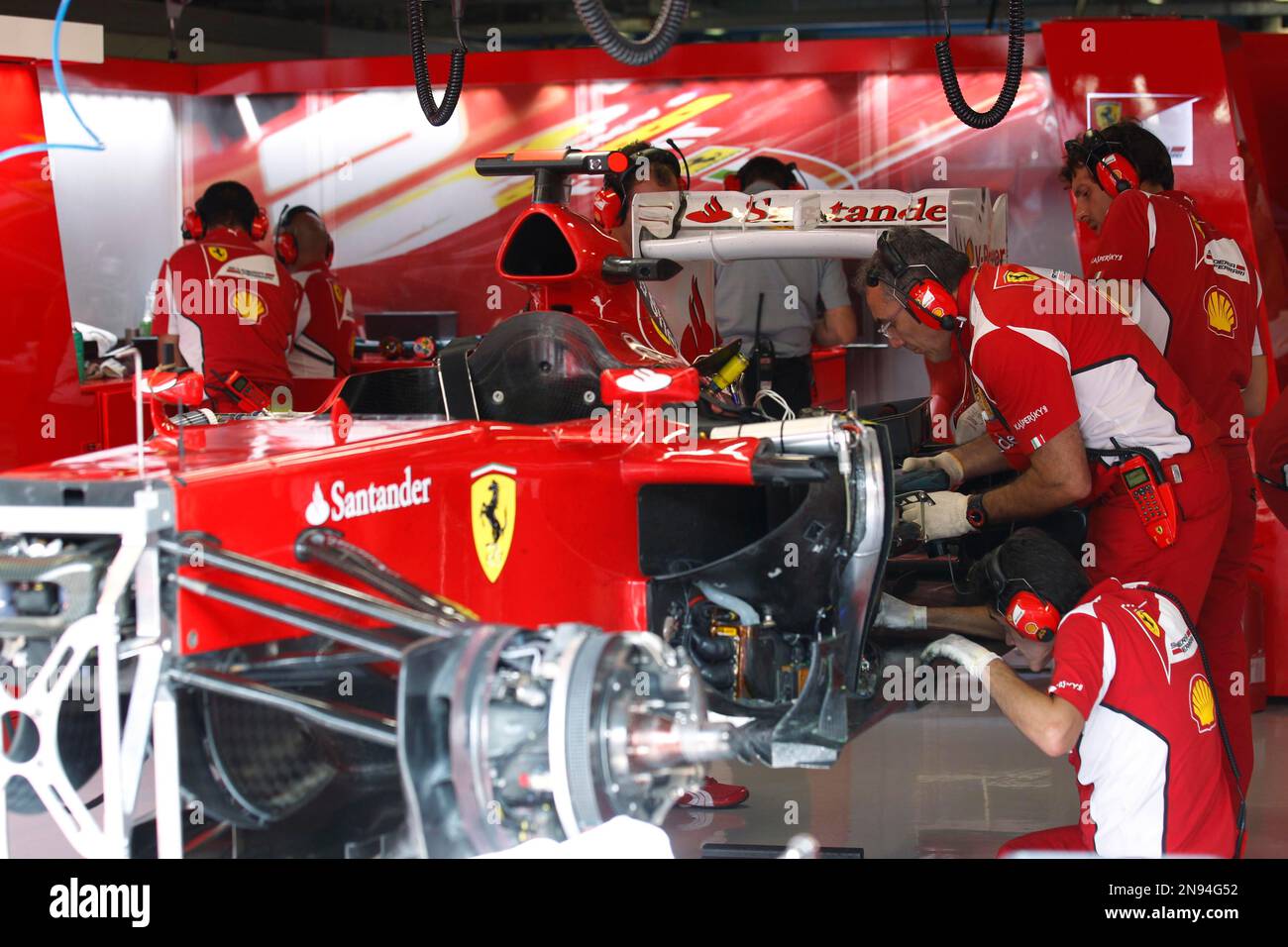 Ferrari mechanics work on the engine of the Fernando Alonso Ferrari car