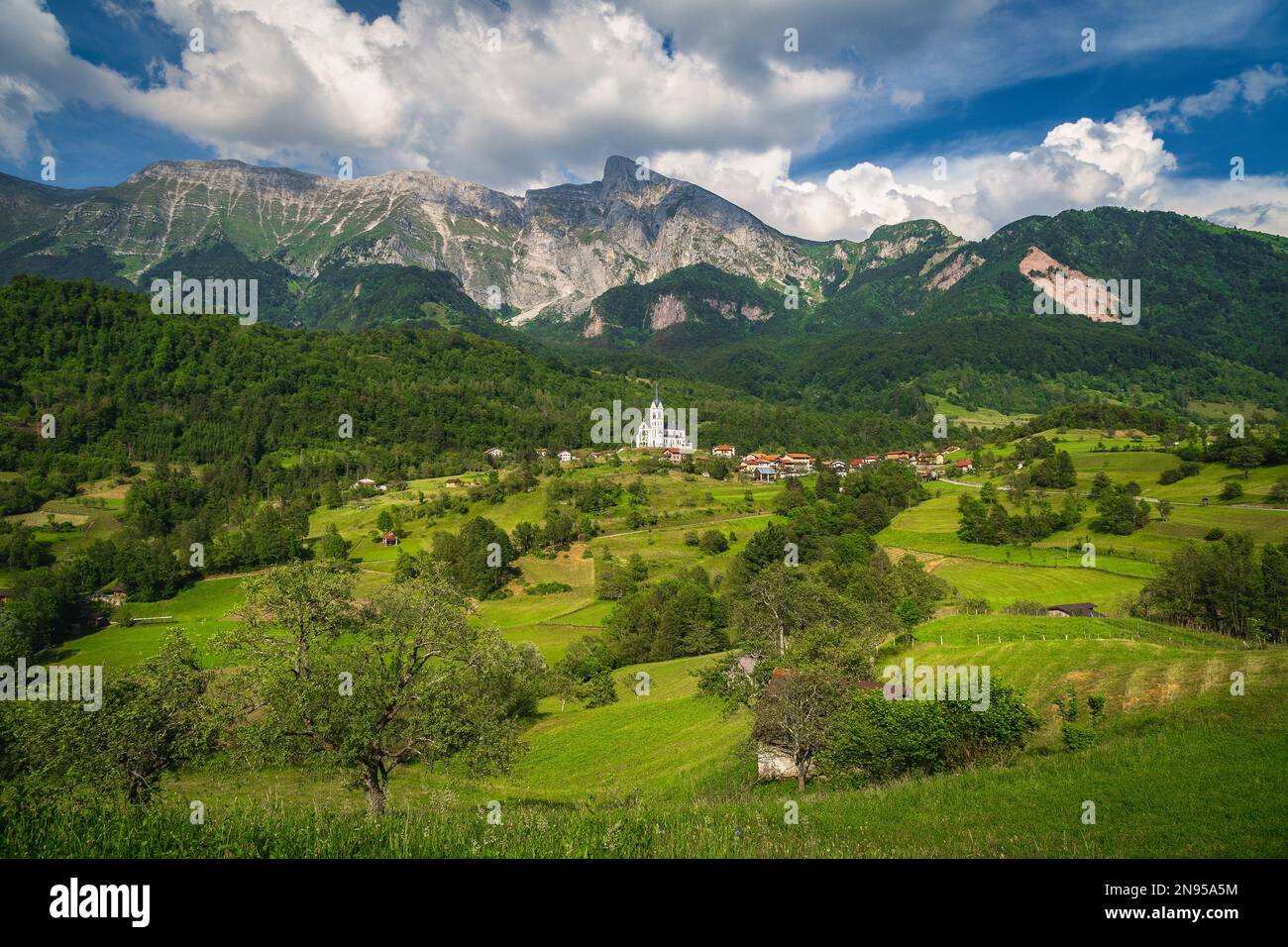 Fantastic travel and hiking destination with high rocky mountains and summer green fields, Dreznica mountain village, Kobarid, Soca valley, Slovenia, Stock Photo