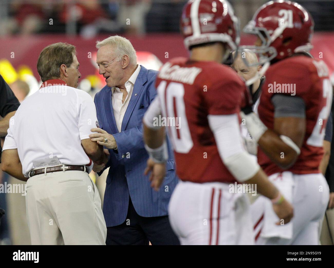 Dallas Cowboys owner Jerry Jones, second from left, greets Alabama head coach Nick Saban before an NCAA college football game against the Michigan at Cowboys Stadium in Arlington, Texas, Saturday, Sept. 1,