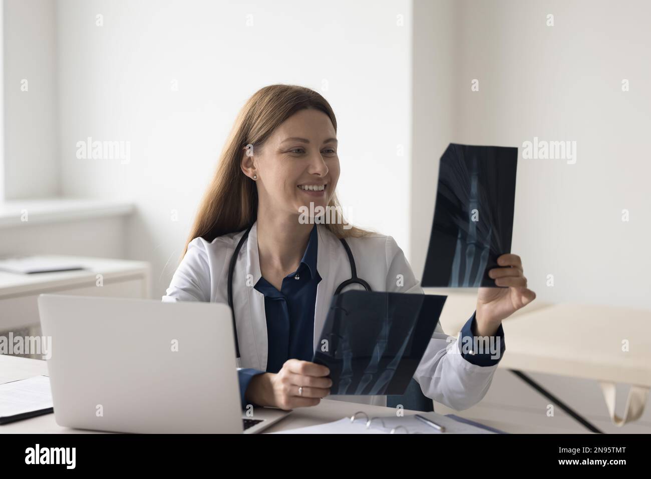 Happy doctor woman looking at radiography shots of radio bones Stock ...