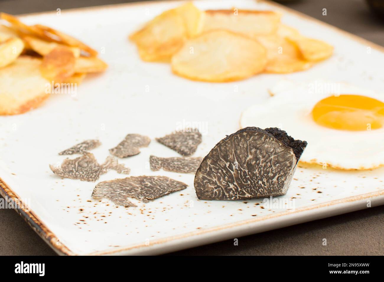 Truffled fried egg with french fries and tuber melanosporum winter