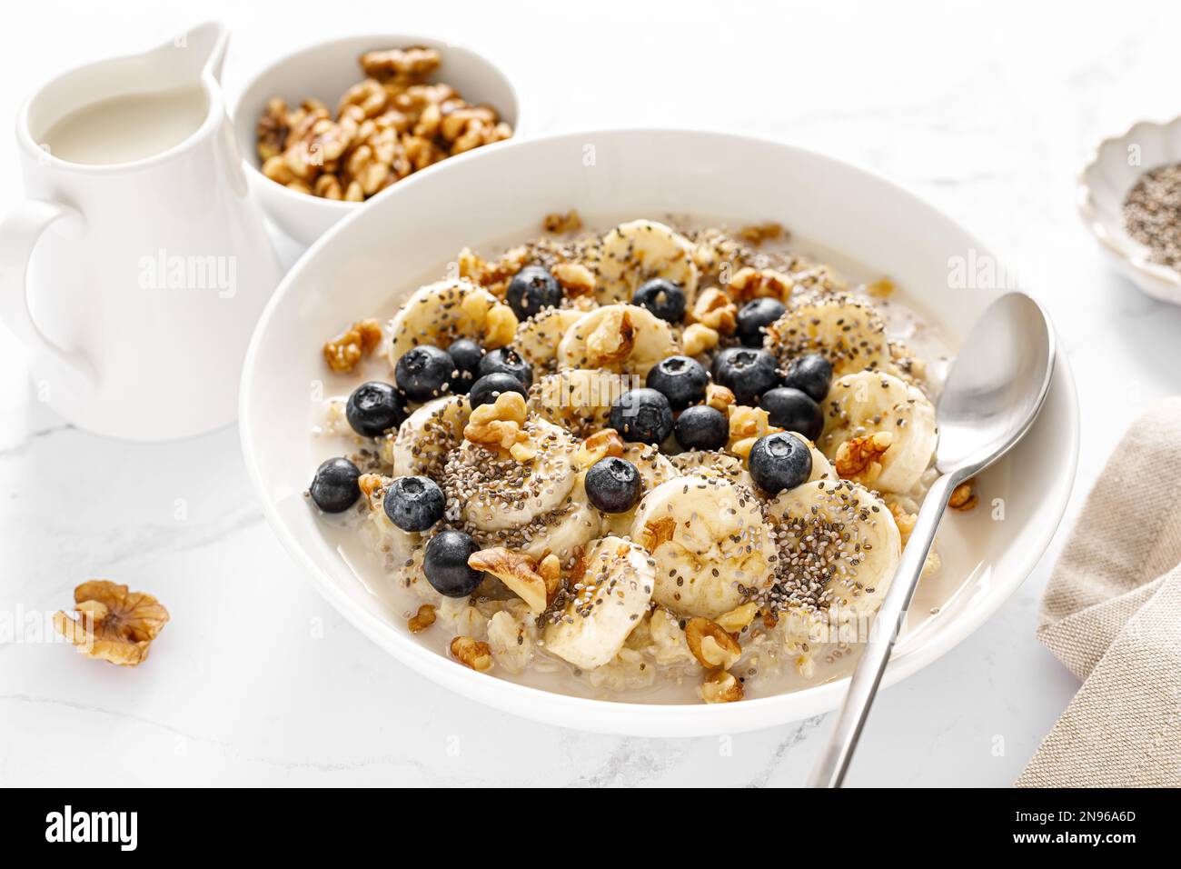 Oatmeal bowl. Oat porridge with banana, blueberry, walnut, chia seeds and oat milk for healthy breakfast. Healthy diet food Stock Photo