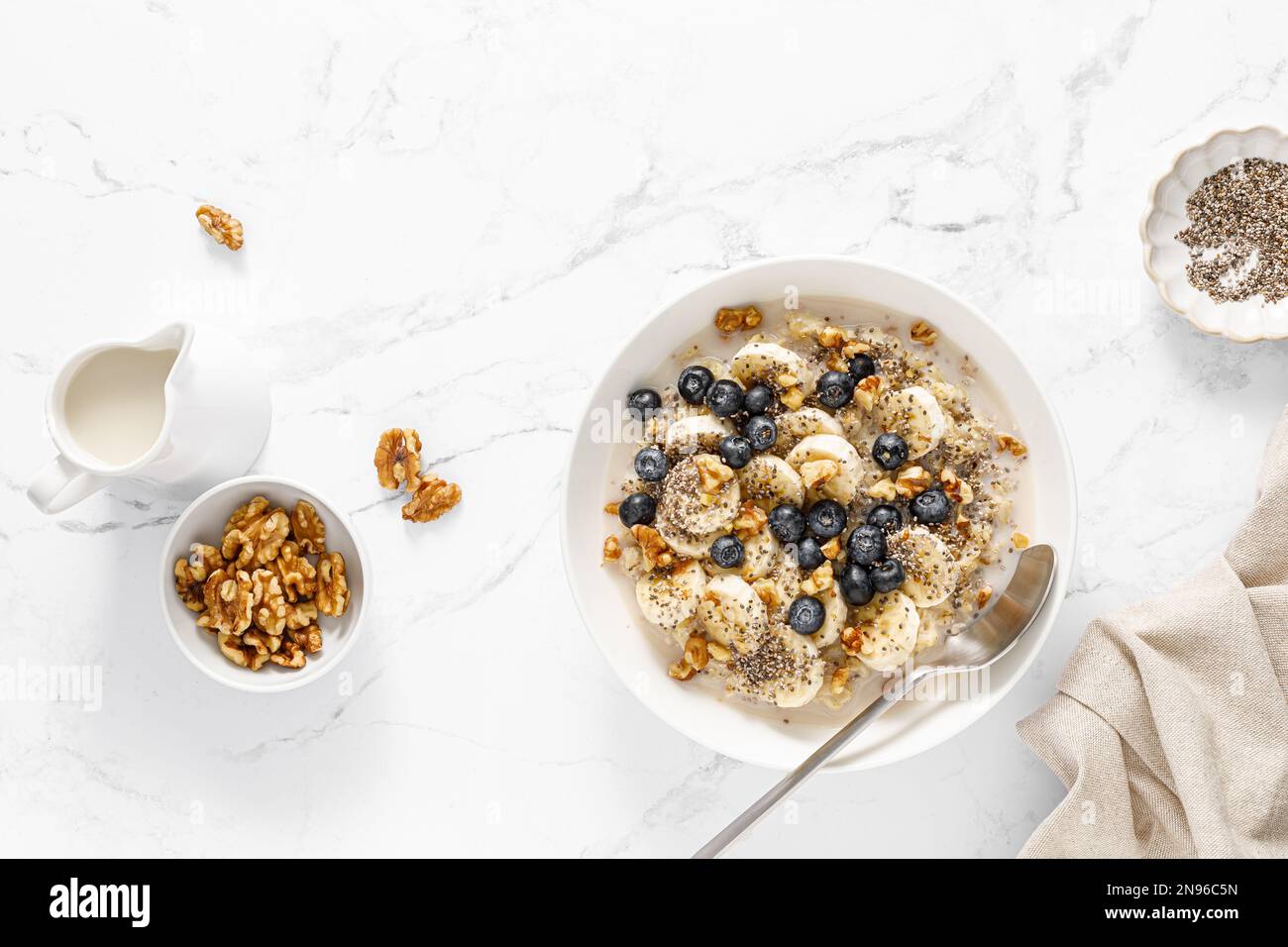 Oatmeal bowl. Oat porridge with banana, blueberry, walnut, chia seeds and oat milk for healthy breakfast. Healthy diet food. Top view Stock Photo