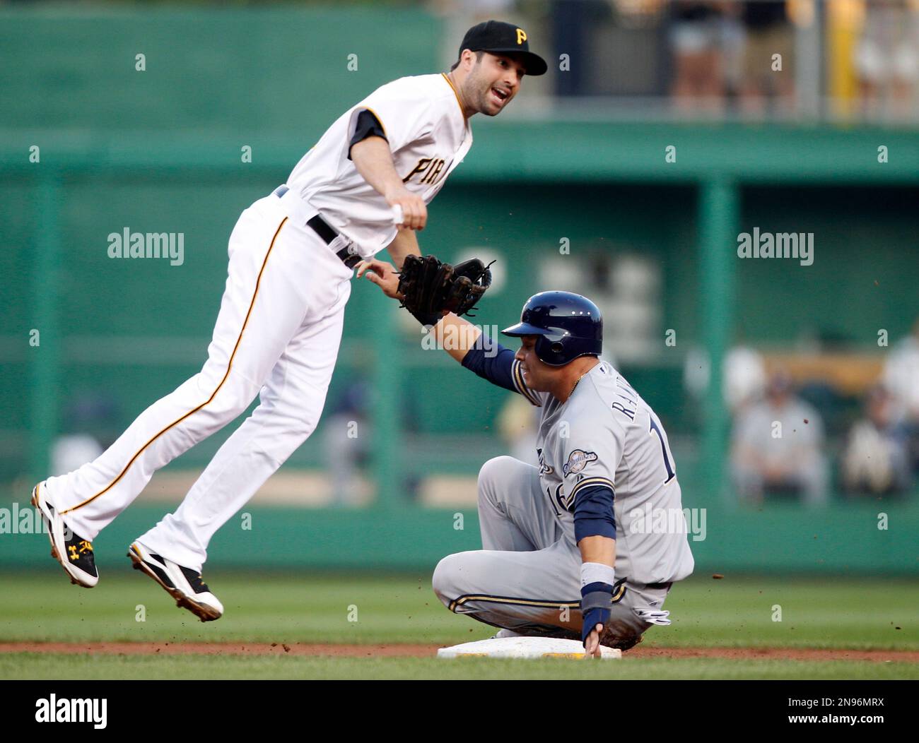 Pittsburgh Pirates second baseman Neil Walker throws on to first to  complete a double play as Milwaukee Brewers' Aramis Ramirez slides to  second in the second inning of the baseball game on