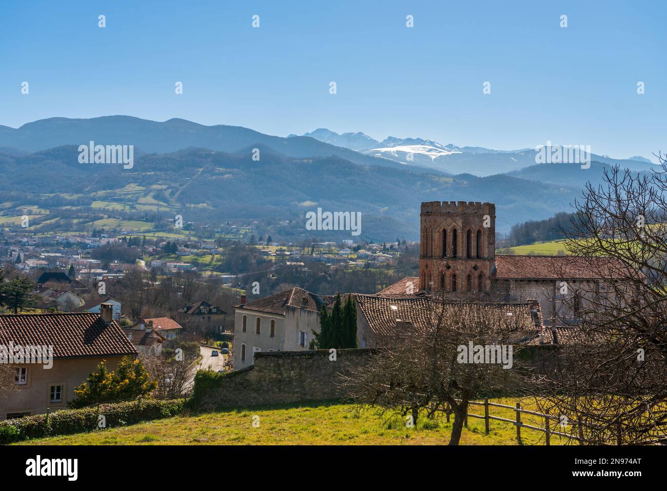 Saint-Lizier Cathedral in Saint-Lizier is a Roman Catholic cathedral, and the Pyrenees in the background, in Ariege, Occitanie, France Stock Photo