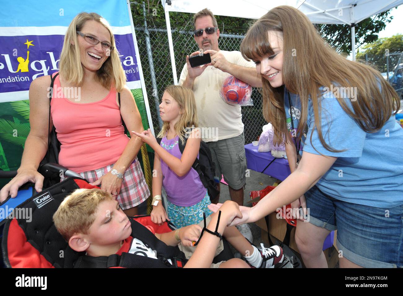 Starlight StarPower Ambassador Kay Panabaker, right, greets children at the  2012 FAME Back-To-School event on Saturday, Aug. 18, 2012, in Los Angeles.  The Starlight Children's Foundation invited families to participate in the