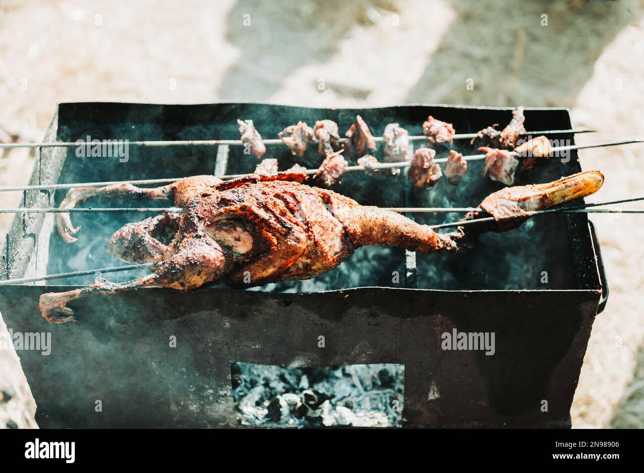 Whole duck barbeque in a charcoal grill Stock Photo - Alamy
