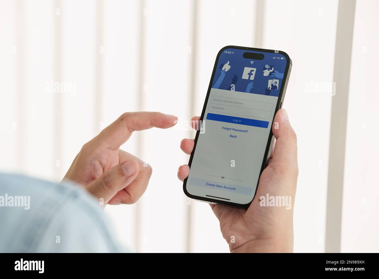 CHIANG MAI ,THAILAND - FEB 12, 2023 : Woman hand using iPhone 14 with facebook application by Metaverse. American digital company, owner of Facebook Stock Photo