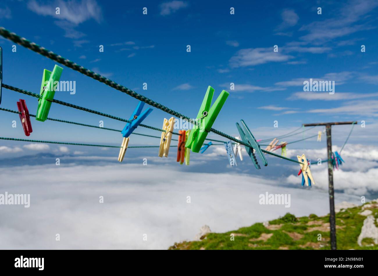 Colorful clothespins on the rope high in the mountains. Alpine laundry. Stock Photo