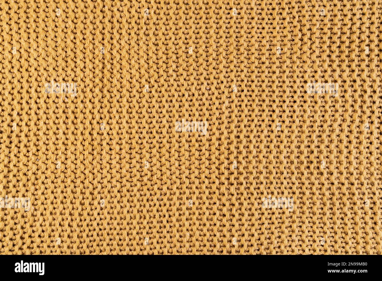 close-up of gold colored knitted fabric, textile background Stock Photo