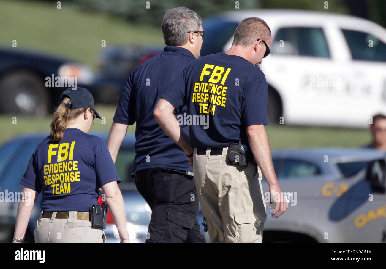 FBI agents walk the perimeter of a Sikh Temple, Sunday, Aug. 5, 2012 ...