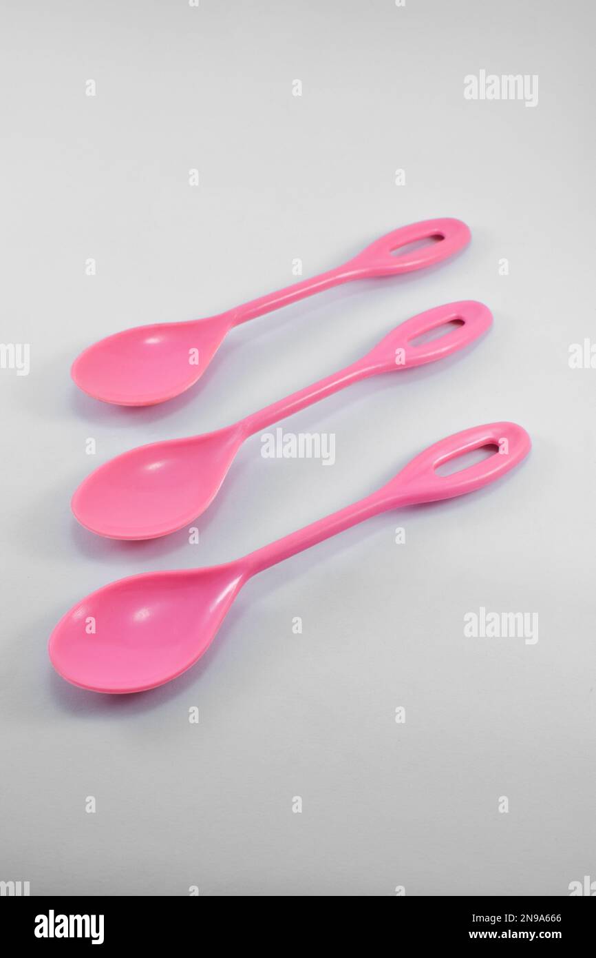 small pink plastic spoon isolated on white background Stock Photo - Alamy