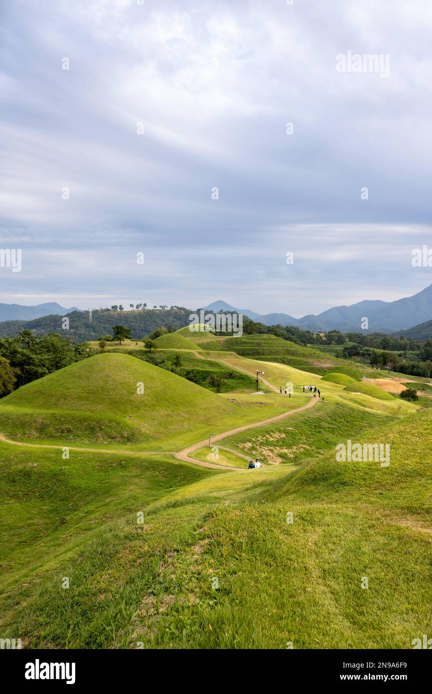 A vertical shot of bright green hills with a path under a blue sky in Gyeongsangnam-do, South Korea Stock Photo