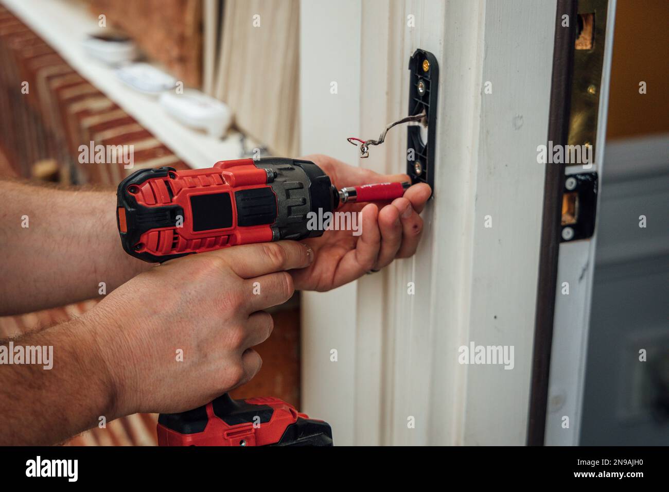 Man carpenter using drill to install door knob Stock Photo