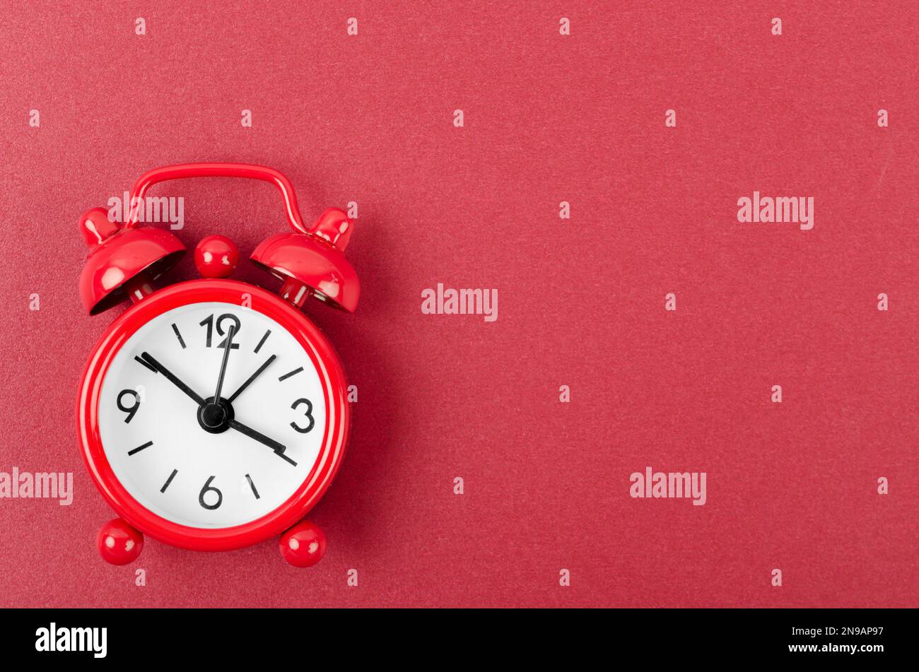 Red alarm clock on red colour background. Stock Photo