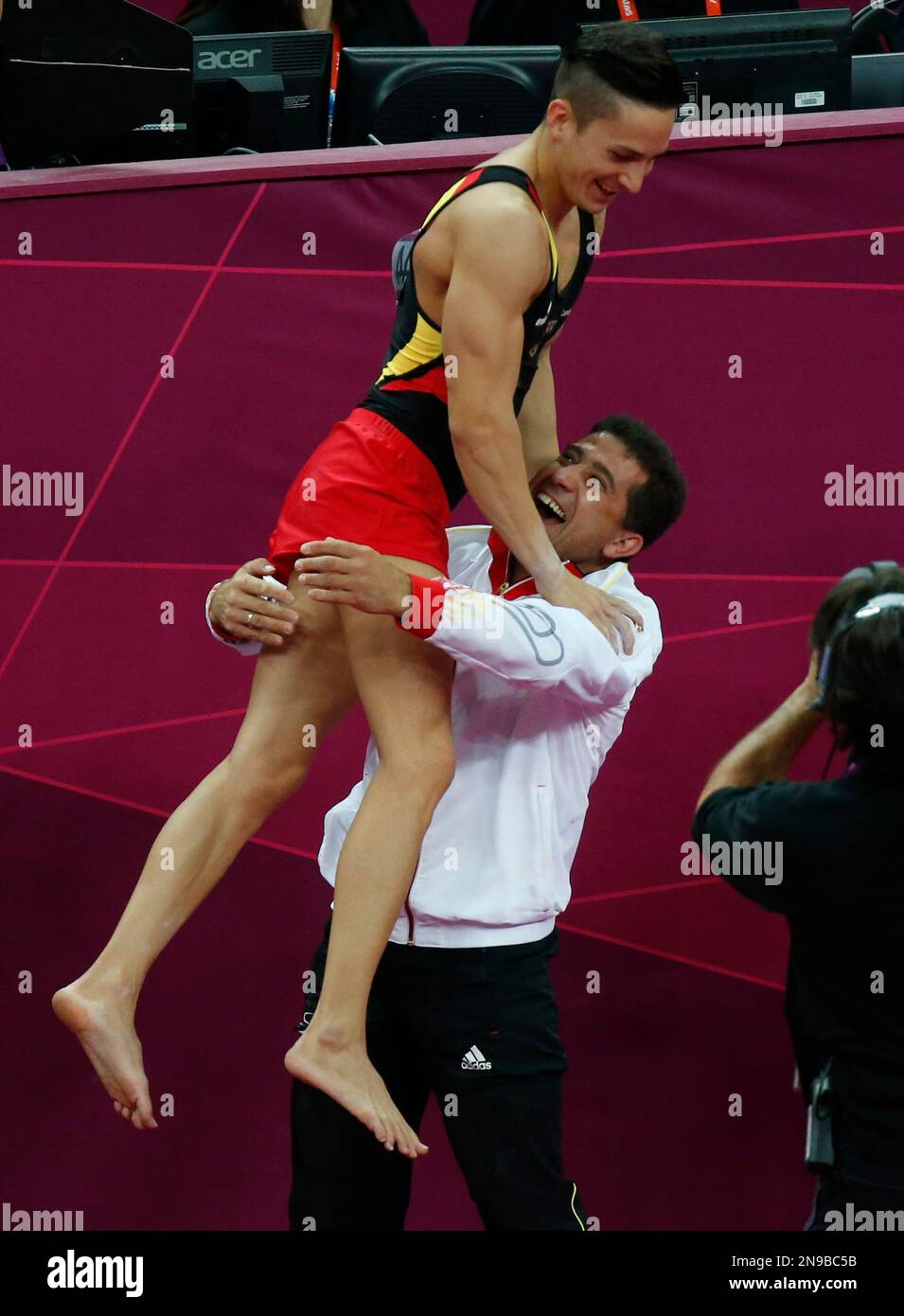 German gymnast Marcel Nyugen jumps on a team official as he celebrates