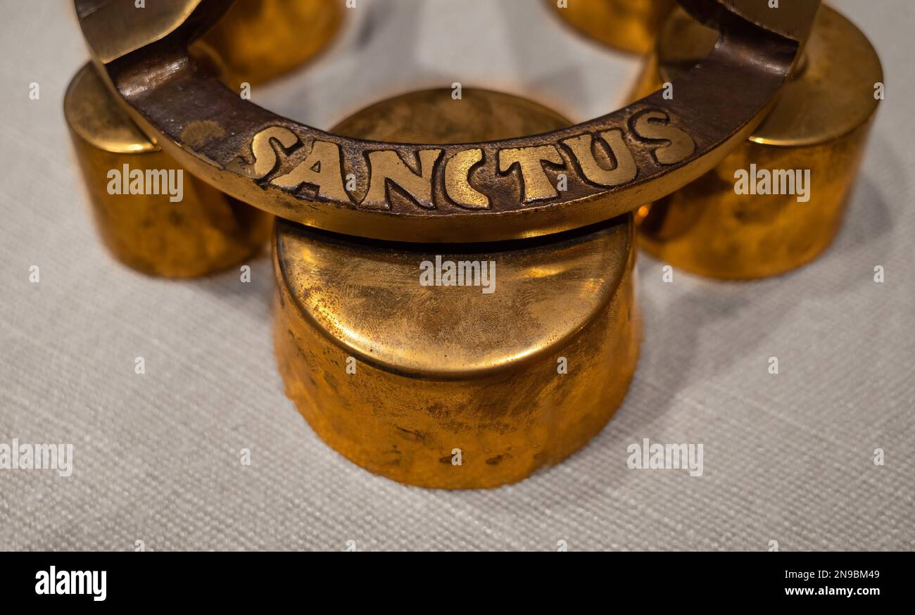 Church hand bell for ringing at mass and other celebrations with a sign