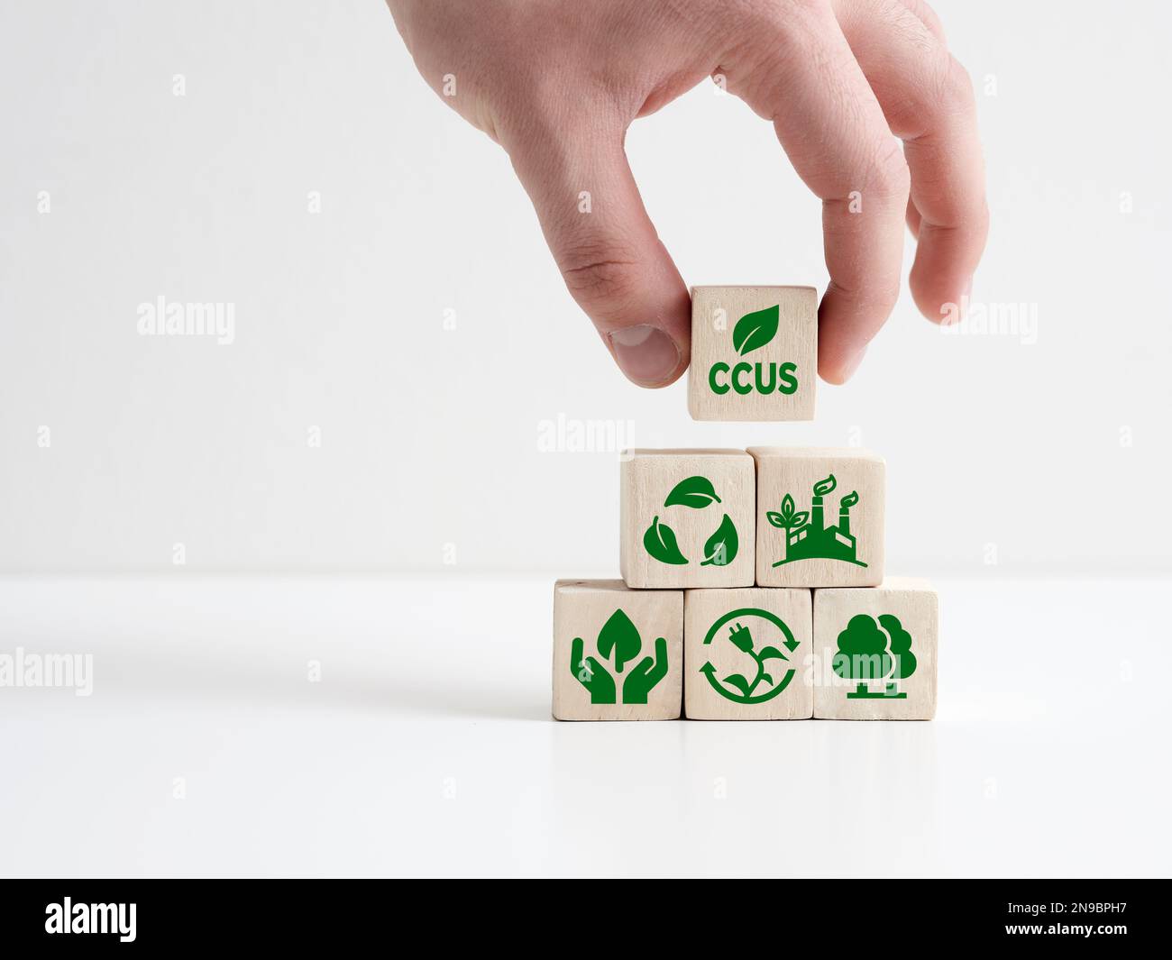 The acronym CCUS Carbon capture, utilization and storage on wooden cubes. CO2 capturing and storage technology. Net zero target to limit global warmin Stock Photo