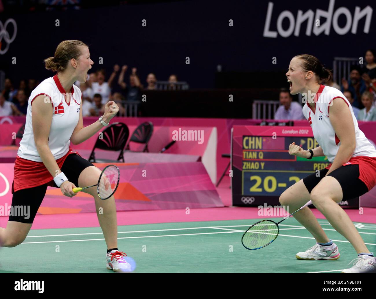 Denmark's Pedersen, left, and Kamilla Rytter Juhl celebrate after winning the first game of the women's doubles badminton match against Tian Qing Zhao Yunlei of China, at the 2012 Summer
