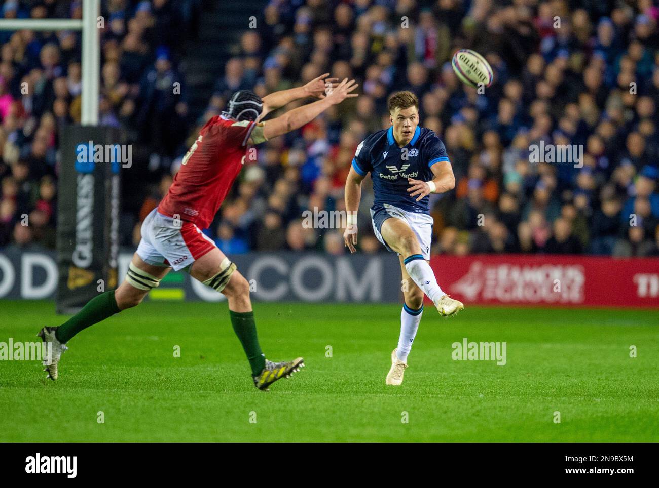 11th February 2023: Guinness Six Nations 2023. ScotlandÕs Huw Jones kicks with Wales Adam Beard challenging during the Scotland v Wales, Guinness Six Nations match at BT Murrayfield,  Edinburgh. Credit: Ian Rutherford Alamy Live News Stock Photo