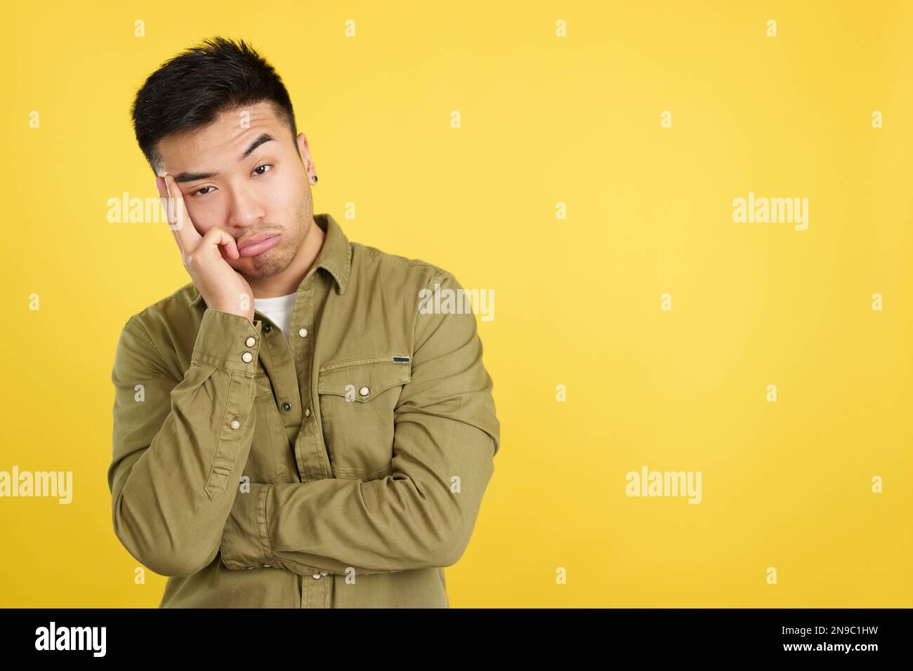 Bored chinese man standing and looking at camera Stock Photo Alamy