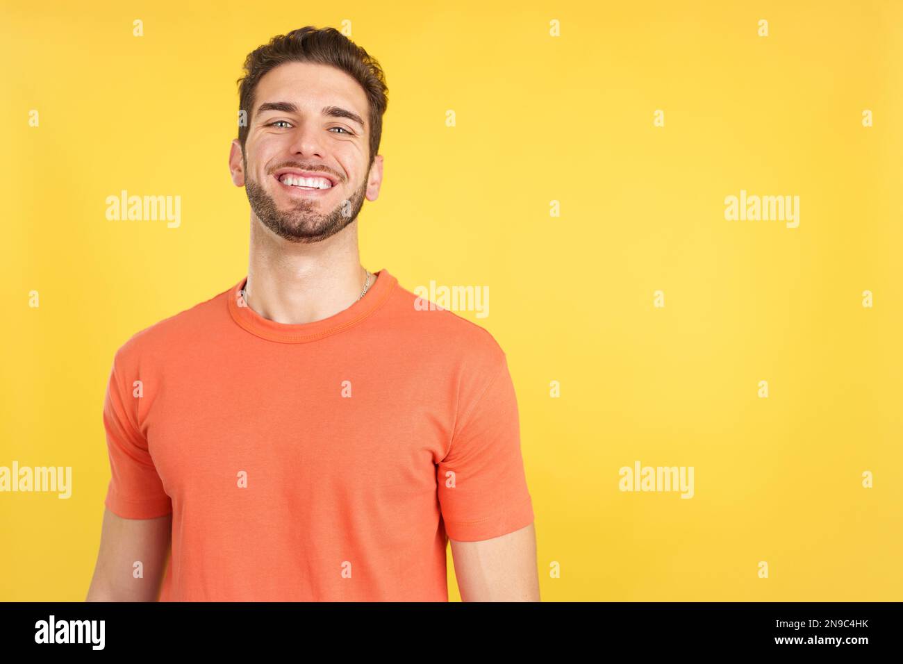 Handsome man standing with arms crossed laughing at the camera Stock Photo