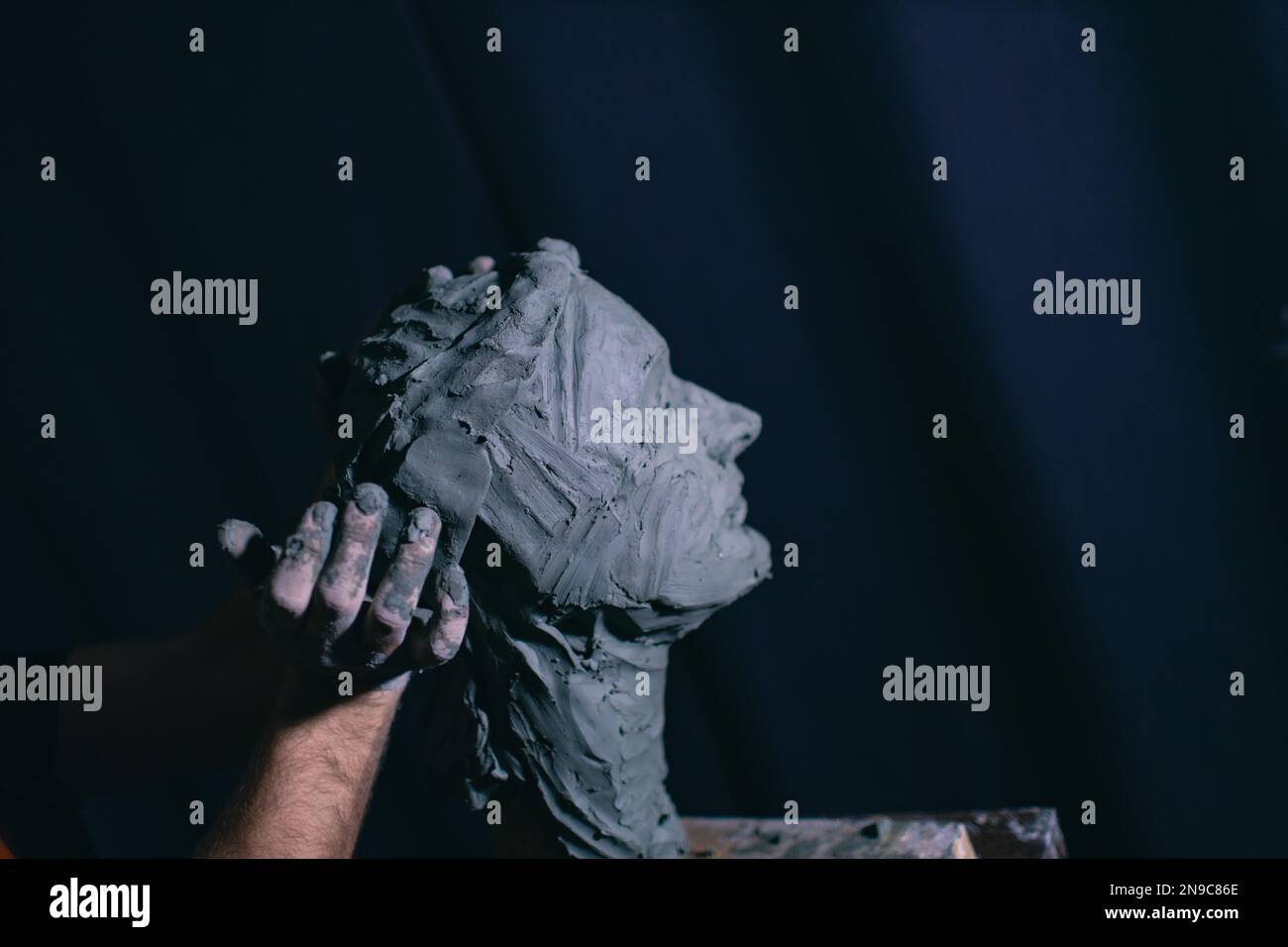 Man sculptor creates sculpt bust clay human woman sculpture. Statue