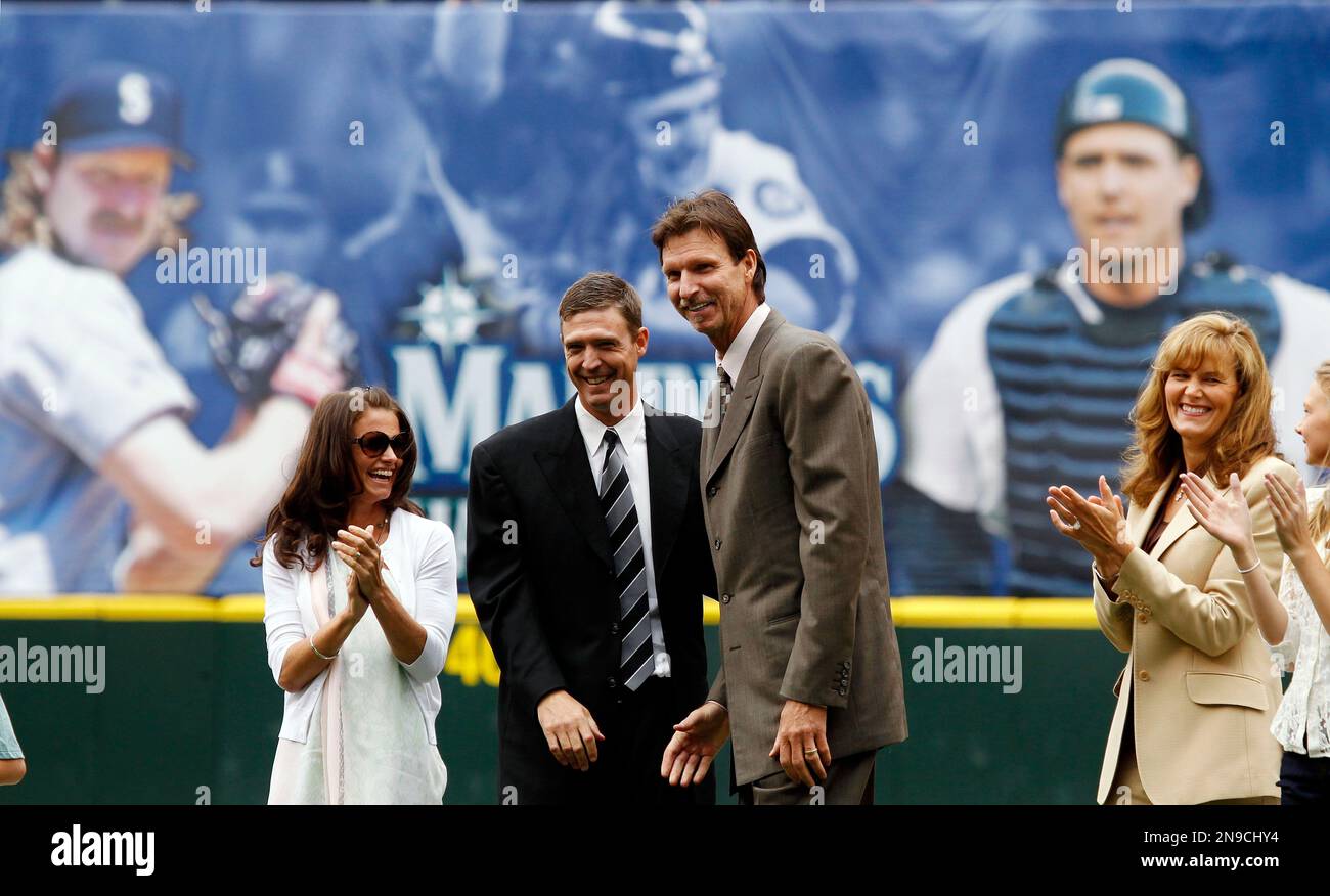 Formers Seattle Mariners' Dan Wilson, second from left, and Randy Johnson  are applauded by their wives Annie Wilson, left, and Lisa Johnson during an  induction ceremony into the Mariners Hall of Fame