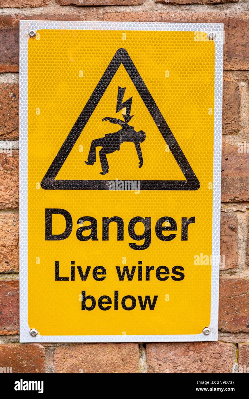 Yellow Danger live wires below warning sign UK Stock Photo